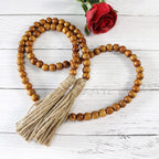 CVHOMEDECO. Wood Grain Beads Garland with Tassels Farmhouse Rustic Wooden Prayer Bead String Wall Hanging Accent for Home Festival Decor. Tan