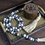 CVHOMEDECO. Wood Beads Garland with Tassels Farmhouse Rustic Wooden Prayer Bead String Wall Hanging Accent for Home Festival Decor. Blue Mix Distressed