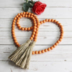 CVHOMEDECO. Wood Beads Garland with Tassels Farmhouse Rustic Wooden Prayer Bead String Wall Hanging Accent for Home Festival Decor. Orange
